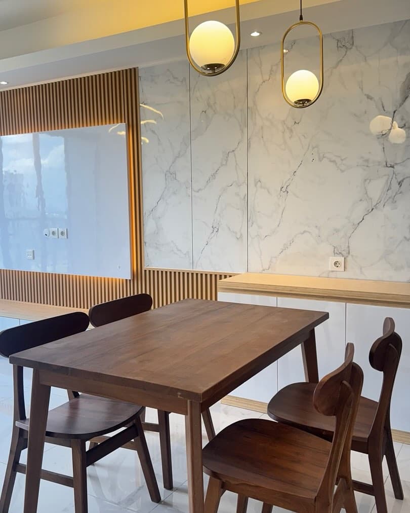 Site photo of the dining table and gold pendant lights after installation
