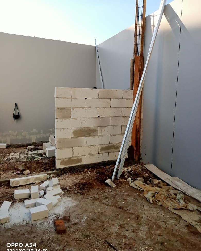 Half-built wall with construction materials on site