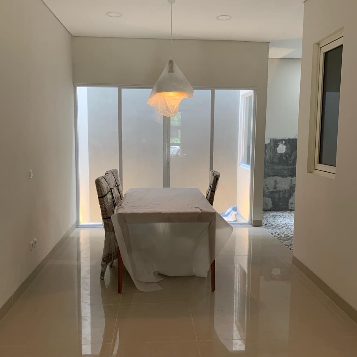Finished dining room with a pendant light and glass blocks